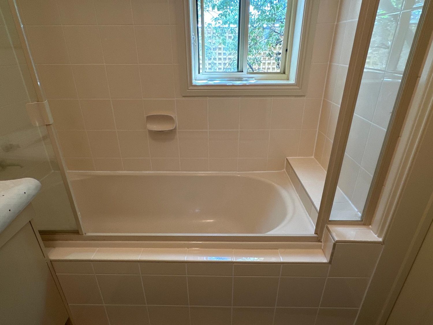 Refreshed bathroom with bath and tiled walls