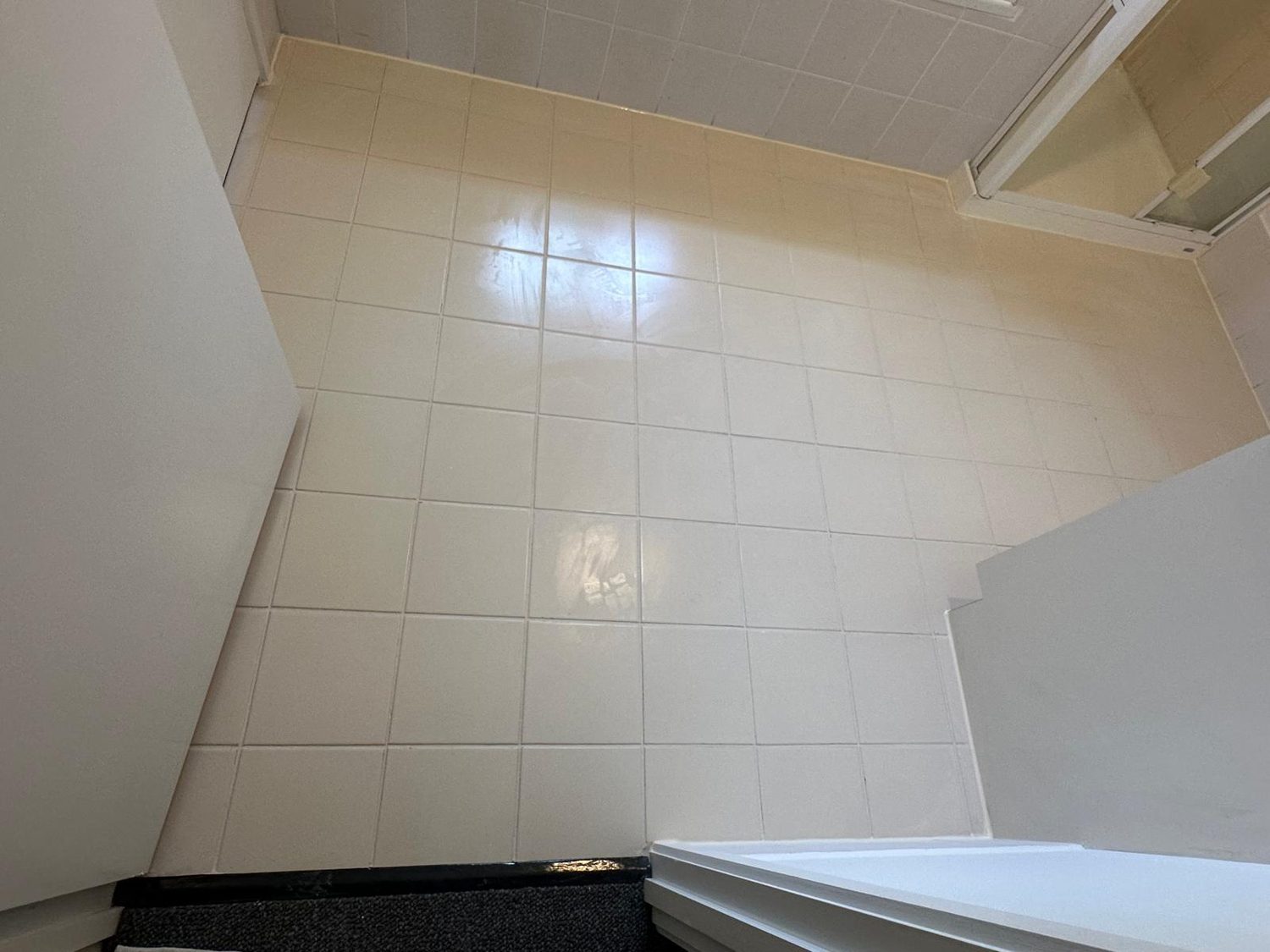 Clean, regrouted white tiled floor