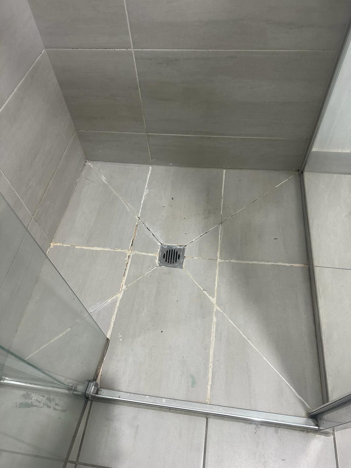 Stone-grey large-format shower floor before regrouting